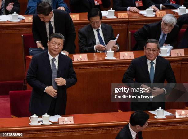 Chinese President Xi Jinping and Premier Li Qiang, right, stand as they prepare to leave after the opening session of the CPPCC, or Chinese Peoples...