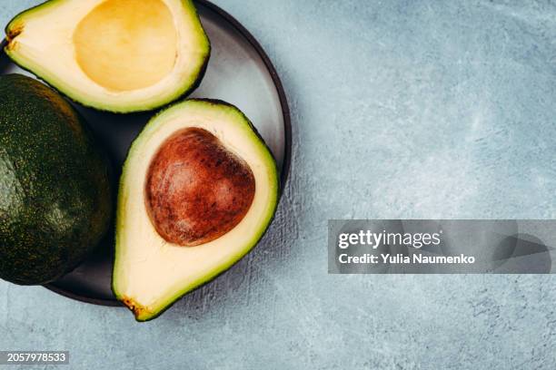 close-up of avocado on the table. - avocado stock pictures, royalty-free photos & images