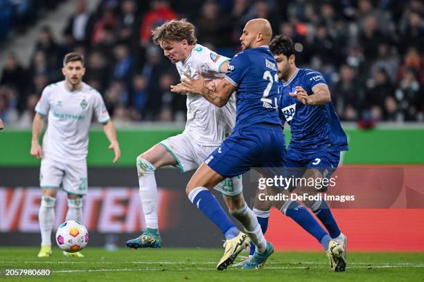 Nick Woltemade of SV Werder Bremen, John Anthony Brooks of TSG 1899 Hoffenheim and Ozan Kabak of TSG 1899 Hoffenheim battle for the ball during the...