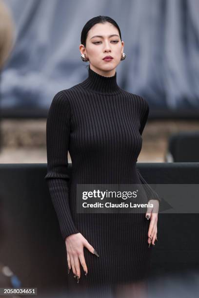 Ayaka Miyoshi wears black turtleneck dress, silver earrings, outside Balenciaga, during the Womenswear Fall/Winter 2024/2025 as part of Paris Fashion...