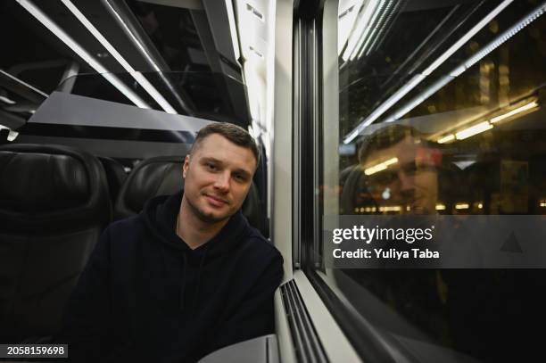 portrait of cheerful man traveling by train at night. - reflection in train window stock pictures, royalty-free photos & images
