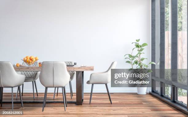 seitenansicht eines modernen esszimmers mit esstisch und stühlen, gartenblick durch fenster im hintergrund - speisezimmer stock-fotos und bilder