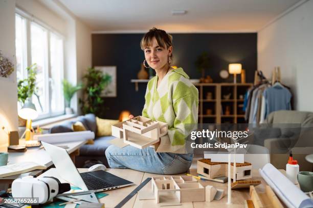 portrait of a female architecture student making architectural model of a modern house - architect stockfoto's en -beelden