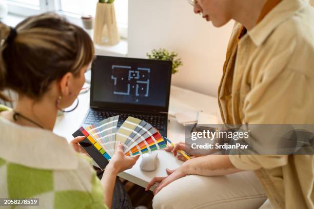 two female designers working on a project together - palet stockfoto's en -beelden