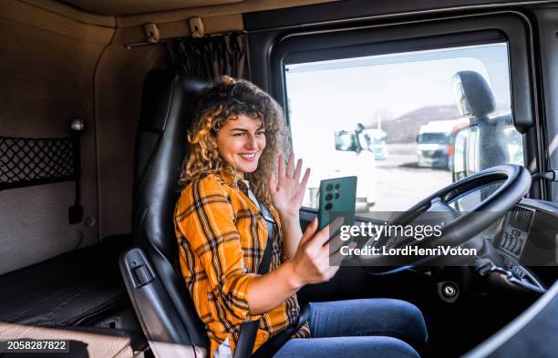 female truck driver having a video call - truck cockpit stock pictures, royalty-free photos & images