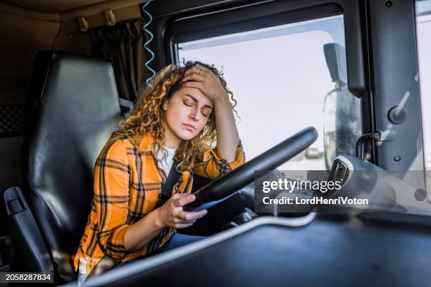 tired truck driver having a headache after working extra hours - vrachtwagenchauffeur stockfoto's en -beelden