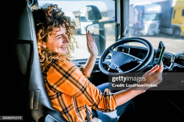 female truck driver having a video call - truck cockpit stock pictures, royalty-free photos & images