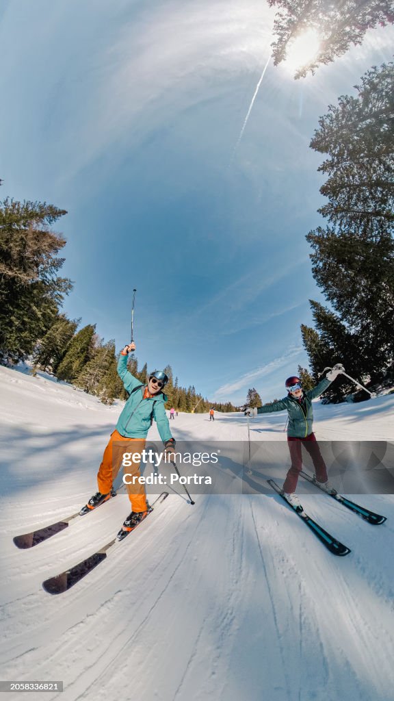 Happy mature couple enjoying skiing at ski resort