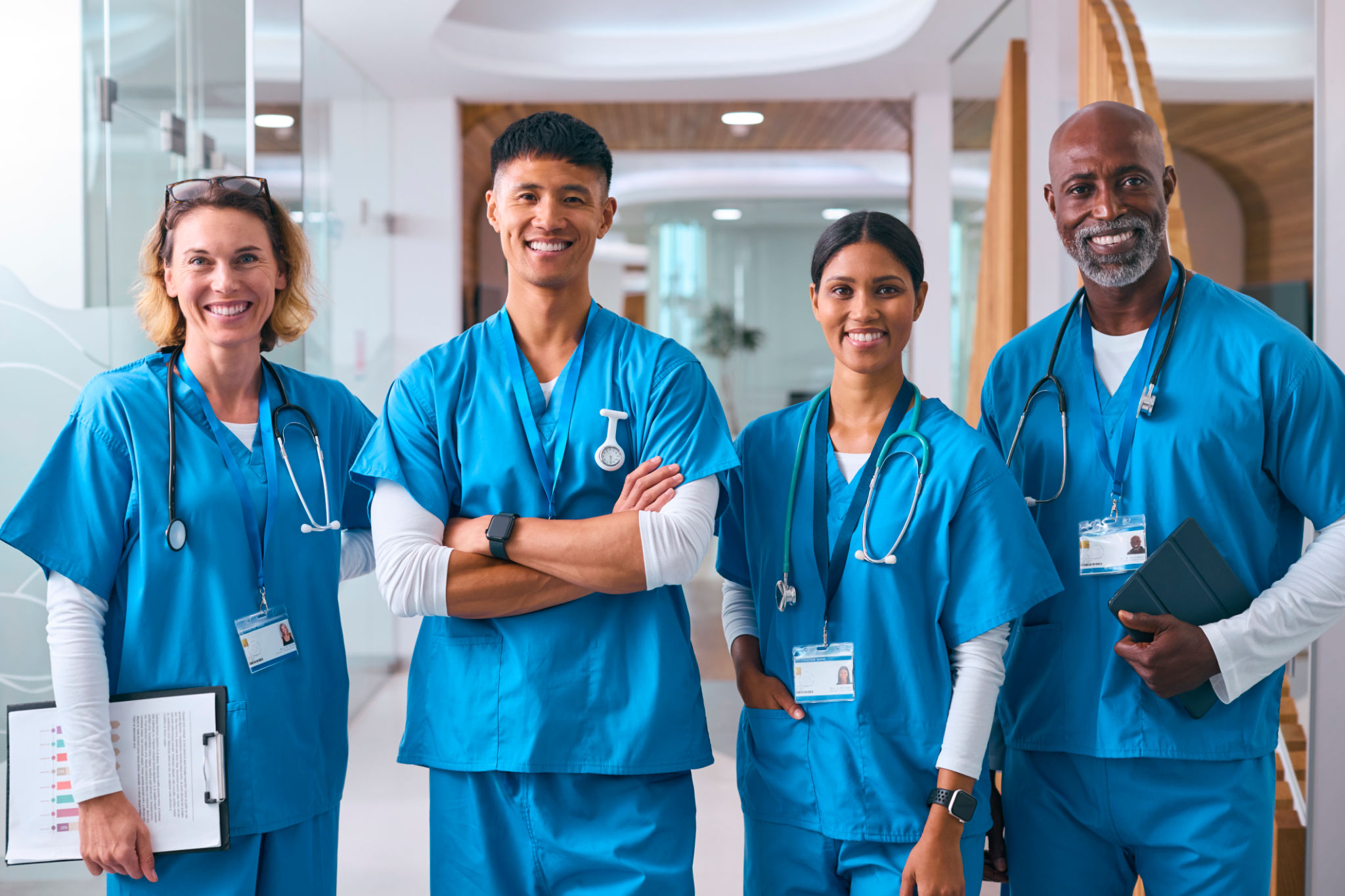 Portrait Of Smiling Multi Cultural Medical Team Wearing Scrubs In Modern Hospital Portrait Of Smiling Multi Cultural Medical Team Wearing Scrubs In Modern Hospital