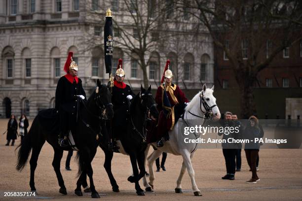 Tourists watch members of the Blues and Royals from the Household Cavalry on Horse Guards Parade, London. Picture date: Thursday March 7, 2024.