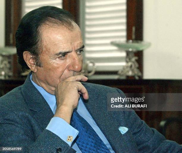 Former Argentinean President, Carlos Menem, speaks with politcians at the residence of the governor of the Rioja province, 25 July 2002El ex...