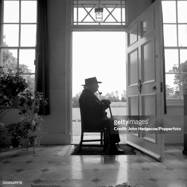 English novelist, writer and playwright John Boynton Priestley , known as J B Priestley, seated on a chair in the doorway of his house in the village...