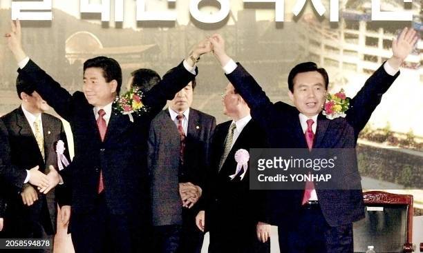 Rhee In-Je competing to become the presidential candidate of South Korea's ruling Millenium Democratic Party , holds up his hands with rival Noh...