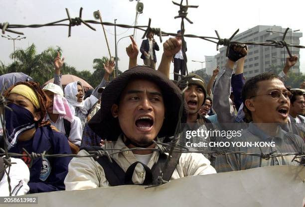 University students of Indonesia shout slogans in front of the main gate of Parliament in Jakarta 25 July 2001, yelling their opposition to...