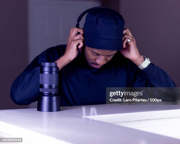 young man using headphones while sitting on table,corpus christi,texas,united states,usa - corpus christi stock pictures, royalty-free photos & images