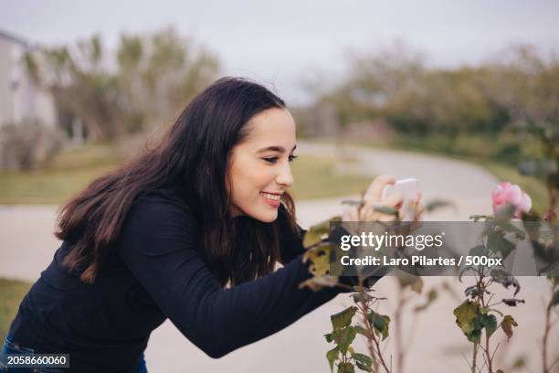 young woman taking a picture of flowers,corpus christi,texas,united states,usa - corpus christi stock pictures, royalty-free photos & images