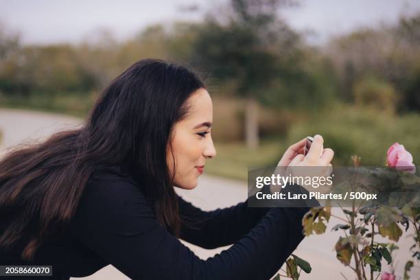 side view of woman photographing by plants,corpus christi,texas,united states,usa - corpus christi stock pictures, royalty-free photos & images