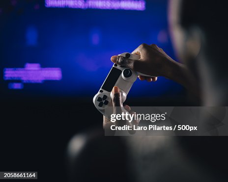 Close-up over the shoulder view of man playing video game at home,Corpus Christi,Texas,United States,USA Close-up over the shoulder view of man playing video game at home,Corpus Christi,Texas,United States,USA