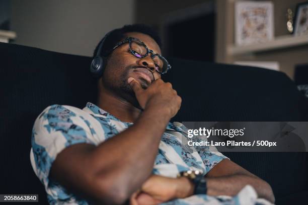 young man listening to music on headphones at home,corpus christi,texas,united states,usa - corpus christi stock pictures, royalty-free photos & images