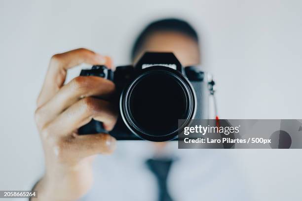 close-up of woman photographing with camera against white background,corpus christi,texas,united states,usa - spiegelreflexkamera stock-fotos und bilder