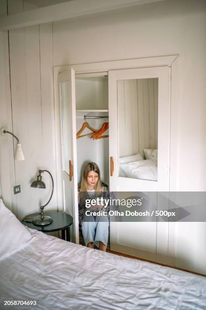 woman reading book while sitting on bed at home,calafell,tarragona,spain - tarragona province stock pictures, royalty-free photos & images