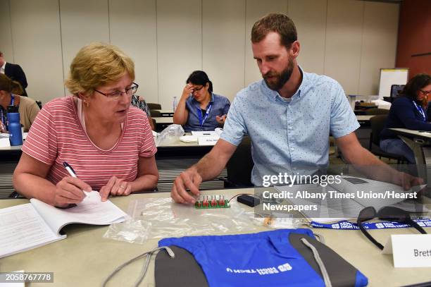 Carol Brown and Brett Bernhard take notes as Capital Region teachers learn about using logic to simulate electron microprocessor flow at New York...