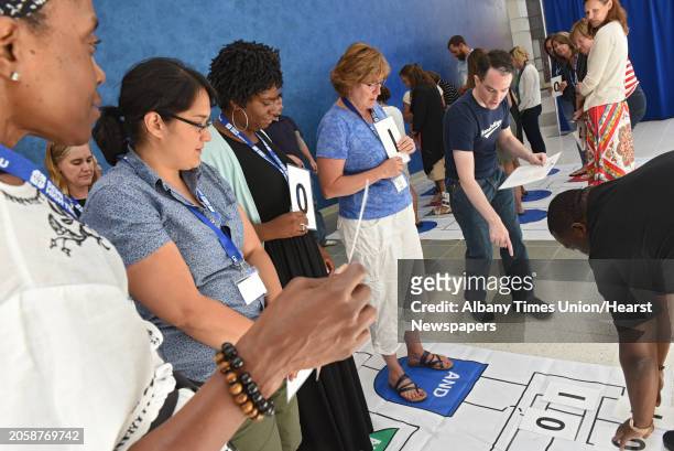 Kevin Musick of SUNY Poly, second from right, points to a number as he helps Capital Region teachers play the "Human Calculator Game," at New York...