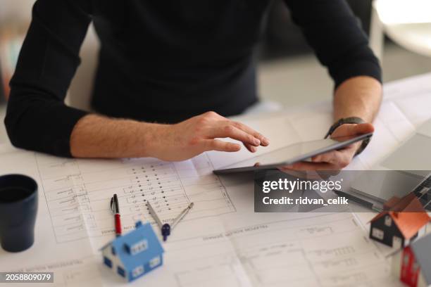 a close-up, an architect, a house designer holding a pencil, pointing to a house plan to examine the design plan before discussing the details with the client. interior design and decoration ideas. - architectural designer stock pictures, royalty-free photos & images