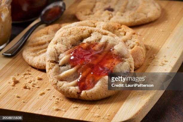 chocolate chip, peanut butter and strawberry jam cookie sandwich's - peanut butter and jelly sandwich stock pictures, royalty-free photos & images
