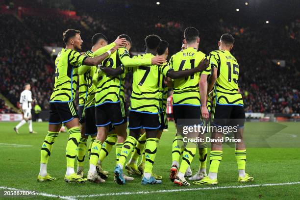 Bukayo Saka of Arsenal celebrates with teammates after his cross leads to an own goal from Jayden Bogle of Sheffield United to give Arsenal their...