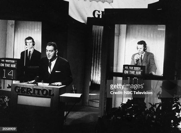 Host Jack Barry stands at the podium as Columbia English professor and contestant Charles Van Doren ponders an answer during a broadcast of the...