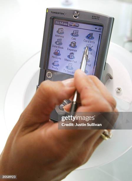 Woman demonstrates a Palm Pilot at the company's headquarters June 5, 2003 in Milpitas, California. Handheld computer maker Palm announced that it...