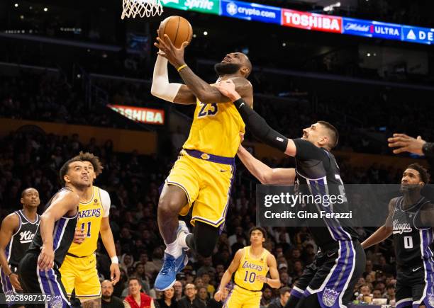 Los Angeles Lakers forward LeBron James is fouled by Sacramento Kings center Alex Len while driving to the basket in the first half on March 6, 2024...