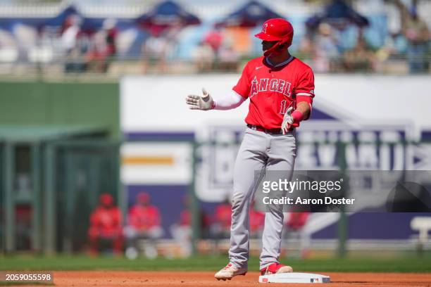 Logan O'Hoppe of the Los Angeles Angels gestures after hitting an RBI double in the first inning during a spring training game against the Texas...