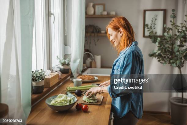 woman making salad in the home kitchen - preparing food stock pictures, royalty-free photos & images