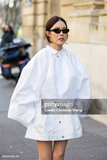 Jenny Tsang wears white oversized blouse, skirt, sunglasses outside Sacai during the Womenswear Fall/Winter 2024/2025 as part of Paris Fashion Week...
