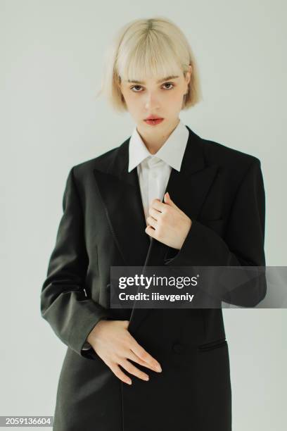 blonde woman in black suit in studio. fashion model. - glamorous female model photoshoot stock pictures, royalty-free photos & images