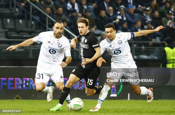Lille's Brazilian defender Ismaily and Lille's French midfielder Benjamin Andre vie for the ball with Sturm Graz's William Boving Vick during the...
