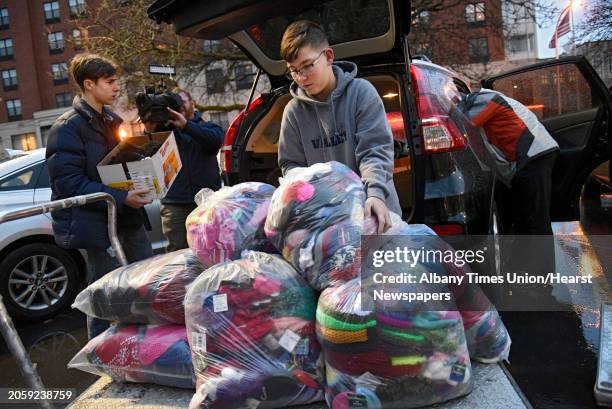 Year-old Dillon Speanburgh of Valley Falls, right, and Jeremy Wernick of Latham, left, unload 900 hats for patients at Albany Medical Center on...