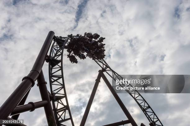 March 2024, Baden-Württemberg, Rust: A train of the "Voltron Nevera" roller coaster runs through a loop loaded with water dummies. The new roller...