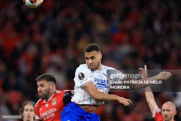 Rangers' Belgian-born Nigerian striker Cyriel Dessers heads the ball next to Benfica's Argentinian defender Nicolas Otamendi during the UEFA Europa...