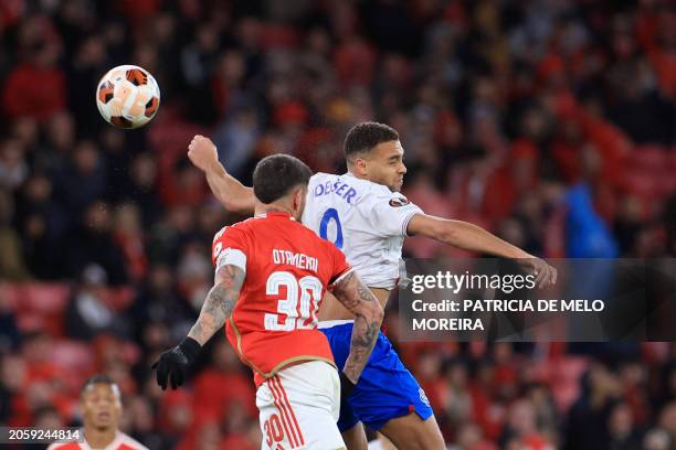 Rangers' Belgian-born Nigerian striker Cyriel Dessers jumps for the ball next to Benfica's Argentinian defender Nicolas Otamendi during the UEFA...