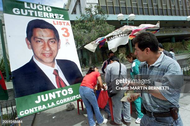 Woman walks by a presidential campaign poster in Quito, Ecuador 15 October 2002. Un tranceunte para frente a una pancarta con propaganda del coronel...