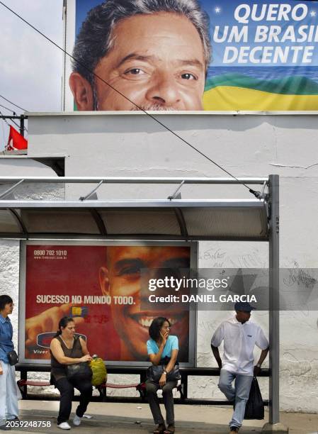 Civilians wait for the bus as banners of presidential candidates ornate the city in Sao Paulo, Brazil 26 October 2002. Un grupo de personas aguardan...