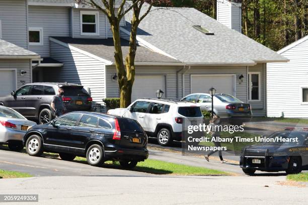 Woman, followed by a state trooper, is seen running down a driveway to get into a state trooper's car during an investigation at Tallow Wood Drive...