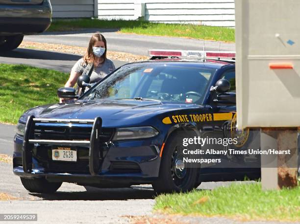 Woman and state trooper get into the state trooper's car during an investigation at Tallow Wood Drive where Gustavo Oliveira was abducted from his...