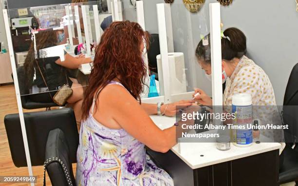Customers receive manicures separated by plastic barriers from each other and from the manicurist at ProNails of Saratoga located on Broadway on...