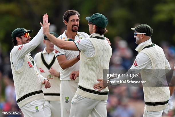 Mitchell Starc of Australia is congratulated by team mates after taking a catch to dismiss Will Young of New Zealand during day one of the Second...