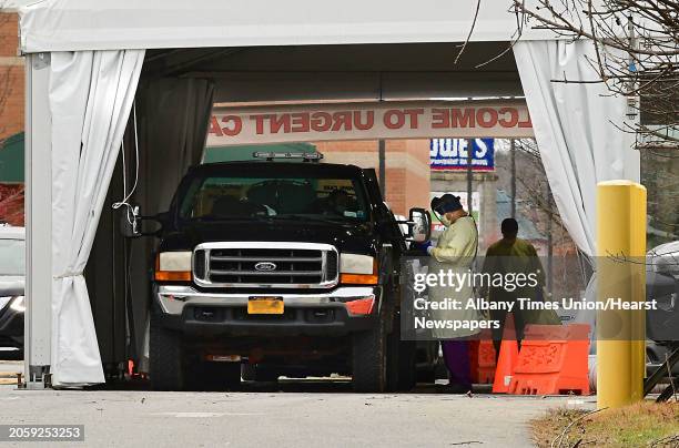 Health care workers tend to patients at a drive-through COVID-19 testing tent set up in the Wilton Medical Arts parking lot on Friday, Dec. 4, 2020...