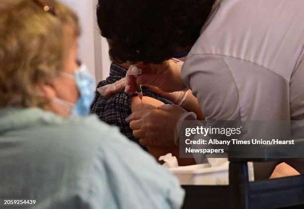 Sixth year pharmacy intern Ryan Stouffer, right, from YoungÕs Pharmacy in Averill Park administers the Moderna COVID-19 vaccine to residents at...